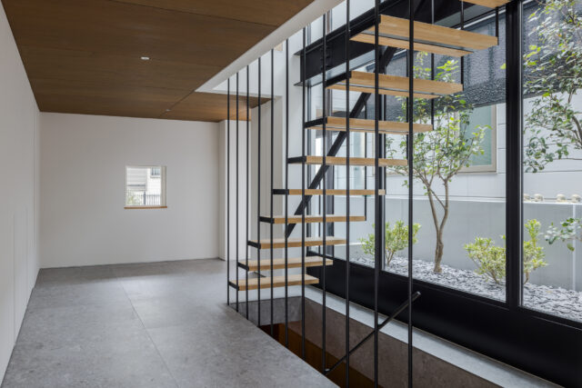 広々とした玄関ホールは、タイル張りの床と白い壁が織りなす洗練された空間。１階は水回りを集約。扉は取っ手のない仕様で壁と一体化。空間の美しさを損なわないよう配慮した。