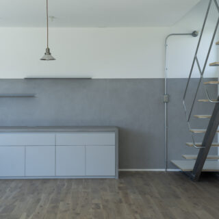 1階LDK。配色を白とグレーに抑えシャープな印象を生み出した。玄関からLDKに入るとまず見えるのがこの風景。ニッチを効果的に使ってほしいと武本さん。視線の高さより上に物を置かなければ空間はシンプルに整えられるため、ニッチの高さも160cm程度にした