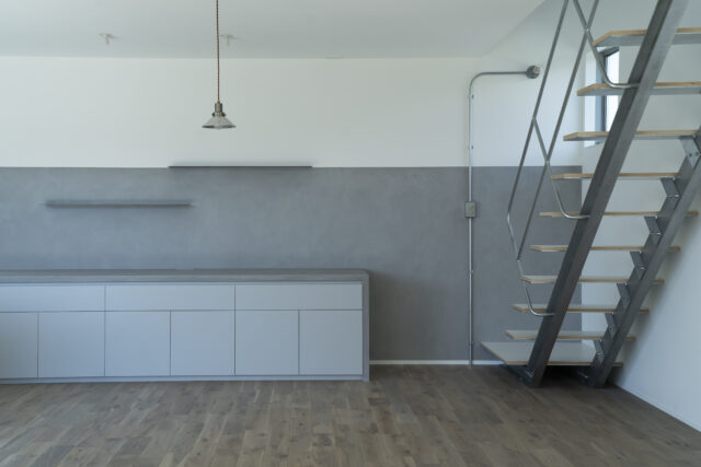 1階LDK。配色を白とグレーに抑えシャープな印象を生み出した。玄関からLDKに入るとまず見えるのがこの風景。ニッチを効果的に使ってほしいと武本さん。視線の高さより上に物を置かなければ空間はシンプルに整えられるため、ニッチの高さも160cm程度にした