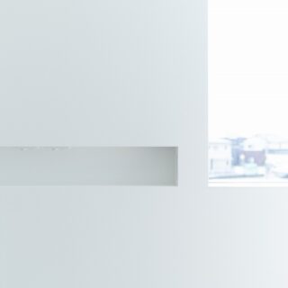 2階寝室。右が夕日を眺めるための大きな窓。画像左、ニッチがある壁面がベッドの枕元になる。お子さまと一緒にベッドに入ったのち、いちいちベッドから出て電気を消しに行く必要がないように、ニッチにスイッチを設けた