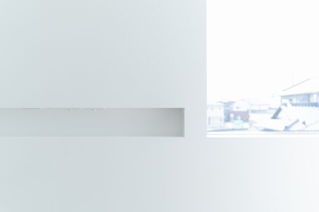 2階寝室。右が夕日を眺めるための大きな窓。画像左、ニッチがある壁面がベッドの枕元になる。お子さまと一緒にベッドに入ったのち、いちいちベッドから出て電気を消しに行く必要がないように、ニッチにスイッチを設けた