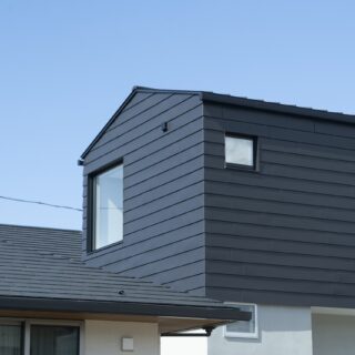 南西から見た外観。大きな窓は寝室のもの。1階は左官仕上げの壁らしく、光や影の表情から手仕事の趣が感じられる