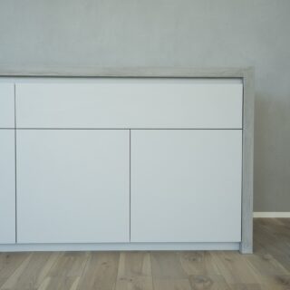 1階、キッチン背面からダイニングまで伸びる収納。プッシュラッチのおかげで、空間全体のシンプル、ミニマルな印象を損なわずに大容量の収納を設置できた。壁面に余計なものを出さないため、コンセントはカウンターの上部に設けた