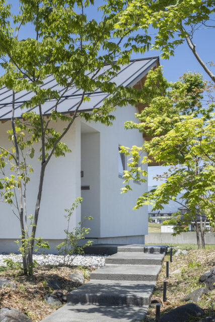 ゆるやかなステップをのぼって玄関へ。緑に彩られたアプローチに心が和む
