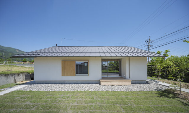 南の庭から見る「西春近の家」は、大きな屋根がゆったりかかった安定感のあるデザイン。シンプルなフォルムだが、ぽっかり空いた濡れ縁などの開口部が奥行きと共に軽やかな個性を感じさせる