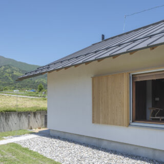 ダイニングの窓の戸袋は木製。左官塗りで仕上げた白い外壁との対比が外観のデザイン性を高めている。雄大な山々を望む緑あふれる風景にもよく馴染む