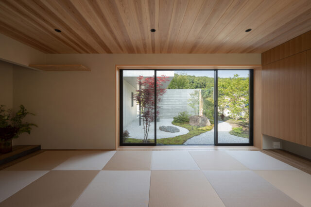1階和室。障子を開けると目に飛び込むのは、和室からのみ眺められる庭。縁のない琉球畳はスッキリとした印象を与え、庭の景色を引き立てる。畳の回りの板は凹凸が付いた仕上げを採用。足触りがよく、来客にも喜ばれているのだとか
