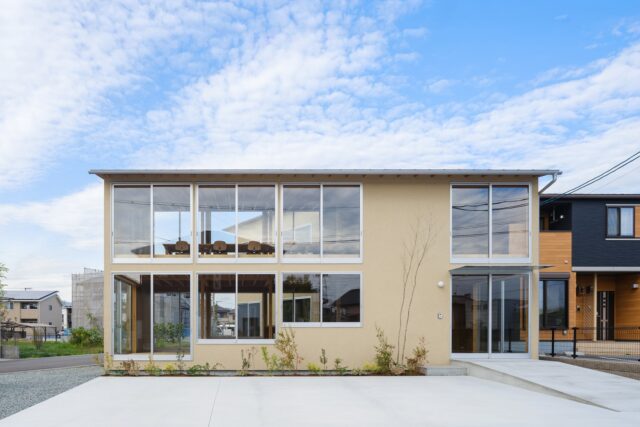 南側から見た外観。右下が入口。１階には機能訓練室を配置し、大きさを変えながら並ぶ連続窓を設けた。２階は事務室。下から延長するような窓を設けることで１階２階がひとつの空間にも見える。中庭側にも同じように窓を計画。視線が反対側へ抜け、オープンな雰囲気が表現されている