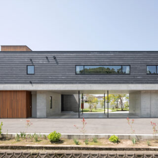 北東側から見た外観。1階RC造、２階木造の混合造を選択し、2階リビングの下を抜いて駐車場を設けることを可能にした。2階左端に物干し場を兼ねたテラスがある。洗濯物を外に見せたくないという奥さまのご要望に応えた