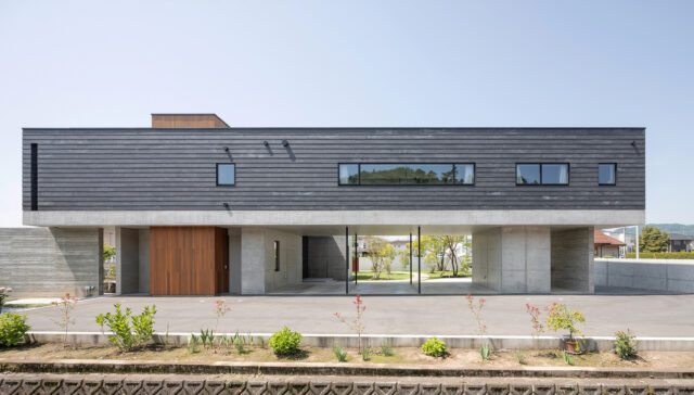 北東側から見た外観。1階RC造、２階木造の混合造を選択し、2階リビングの下を抜いて駐車場を設けることを可能にした。2階左端に物干し場を兼ねたテラスがある。洗濯物を外に見せたくないという奥さまのご要望に応えた