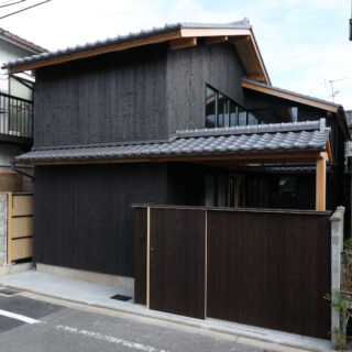 現代に蘇った、京町家。杉板の外壁、瓦、敷地いっぱいに続く軒が町家らしさを再現している