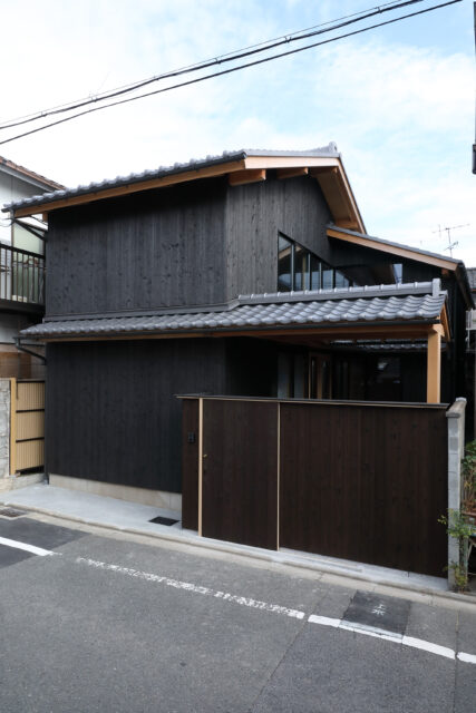 現代に蘇った、京町家。杉板の外壁、瓦、敷地いっぱいに続く軒が町家らしさを再現している