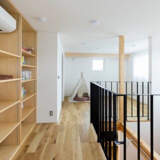 2階、洋室前から全体を見渡す。画像右、南側の窓からは山の稜線が見え、眺めがいい。この家の壁面は全てご主人が塗装したとのこと。家づくりの当初からやってみたいと希望されていたのだとか。質の良い塗り壁をコストを抑えて実現したのはもちろんだが、なにより思い出になった