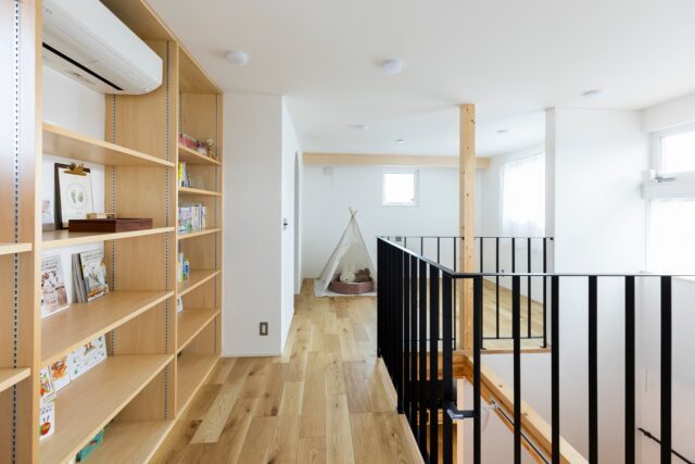2階、洋室前から全体を見渡す。画像右、南側の窓からは山の稜線が見え、眺めがいい。この家の壁面は全てご主人が塗装したとのこと。家づくりの当初からやってみたいと希望されていたのだとか。質の良い塗り壁をコストを抑えて実現したのはもちろんだが、なにより思い出になった
