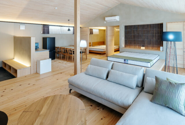 玄関方向から全体を見渡す。玄関を入ると上質な素材にあふれた大空間が広がり、特別な時間の始まりを期待してしまう。A棟は、内装のタイルなどの色合いをすべて変えたという。「リピートでいらしたときに違うお部屋にお泊りいただくのもいいですね」と大類さん
