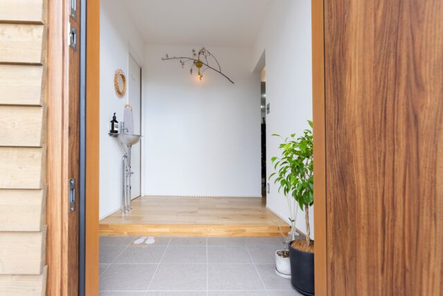 玄関。土間スペースは左に設けられたシューズクローゼットにも伸びる。右奥の開口を進むとLDKがある。あえて仕切り戸を設けず、LDKの開放的な雰囲気を強調した