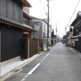 この作品の前から見た街並み。今は古い町家と現代の家が混在している。将来、この通りが現代的な町家が続く街並みとなることを目指している