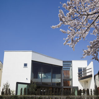 神田川の遊歩道に面した南側。日本の砂を使った白漆喰が美しい。L字型の敷地をいっぱいに使った建物は、エントランスホールでボリュームを２つに分けている。
