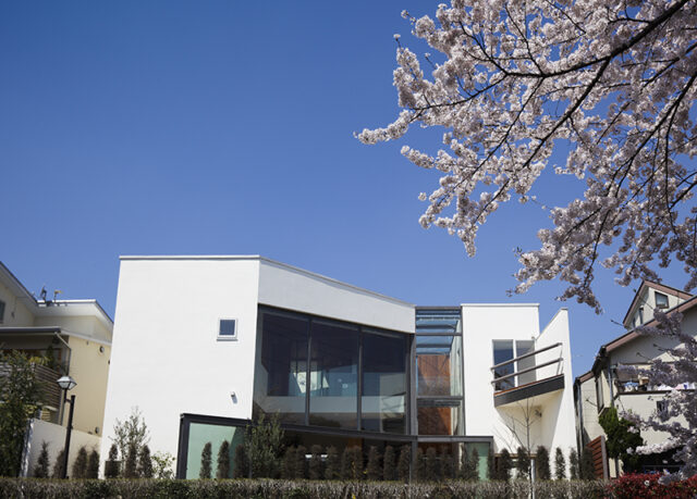 神田川の遊歩道に面した南側。日本の砂を使った白漆喰が美しい。L字型の敷地をいっぱいに使った建物は、エントランスホールでボリュームを２つに分けている。
