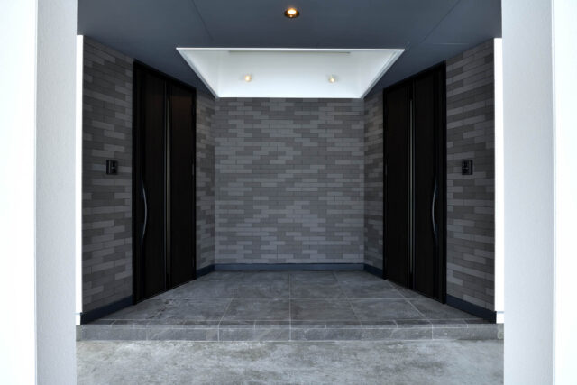 中央にある共有のエントランスは、天井が吹き抜けとなっていて、光が降り注ぐ。親世帯・子世帯で独立した玄関をもつ、完全分離型二世帯だ。