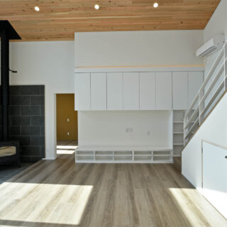 親世帯は約30畳の大空間。白壁とフローリング、杉の天井によって温もりを感じられる空間。広さだけでなく、吹き抜けの天井がより空間に広がりを感じさせている。