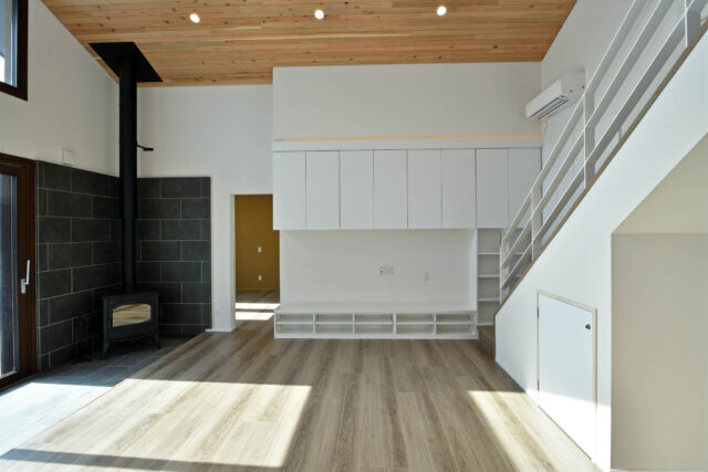 親世帯は約30畳の大空間。白壁とフローリング、杉の天井によって温もりを感じられる空間。広さだけでなく、吹き抜けの天井がより空間に広がりを感じさせている。