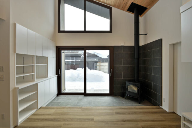南側には、縁側のような土間が。デッキと合わせリビングの延長にもなるという。トリプルガラスの大窓と薪ストーブによって、土間が蓄熱され、冬の光熱費も驚くほど下がったとか。