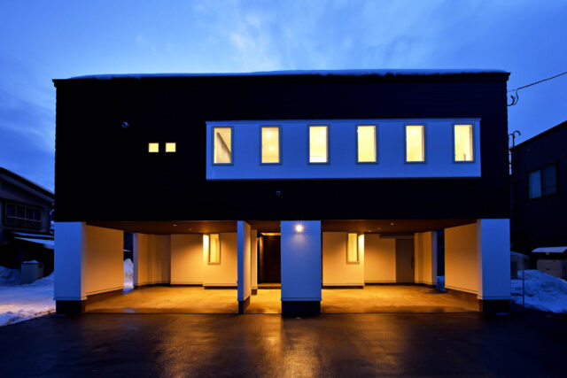 大人１人１台、計４台分のビルトインガレージをもつT邸。夜になり灯がつくとモダンさに拍車がかかる。