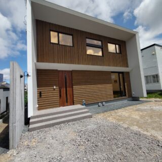 外観。家を囲った深い庇が家を強風や雪、雨から守る。家の左にあるコンクリート壁も、風除けとして設けた