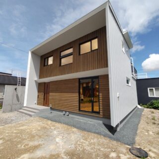 外観。屋根はゼロ勾配のフラットなデザイン。外壁を伝って雨や雪が落ちないよう両側の奥に小さな庇を付けた