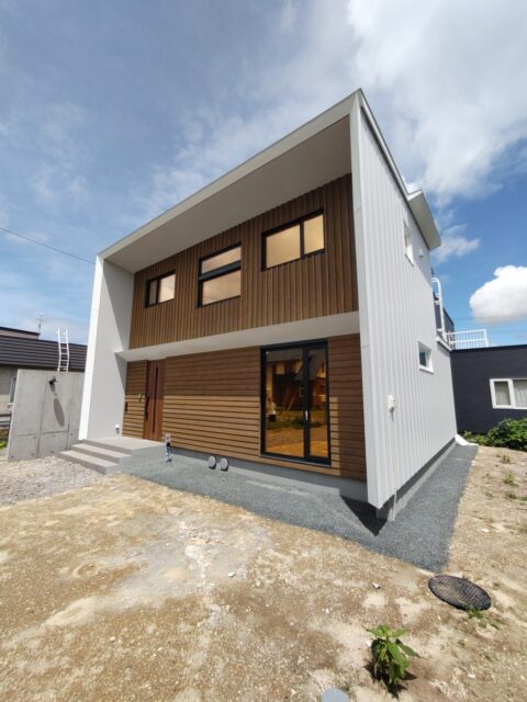 外観。屋根はゼロ勾配のフラットなデザイン。外壁を伝って雨や雪が落ちないよう両側の奥に小さな庇を付けた