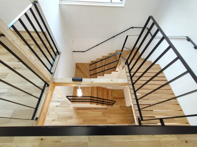 2階吹き抜けから1階を見下ろす。階段と2階を結ぶブリッジは要望から簀の子を採用。視線や光が抜け、縦のつながりが一層感じられるようになった。吹き抜けの上部には開閉できる窓を計画。風が通り、一年を通して快適に暮らせる