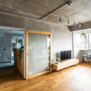 フローリングに用いたのは180mmの幅広のオーク材。玄関から奥に向かって貼るのが一般的だが、同物件ではあえて大きな窓とバルコニーがある東西に向けて貼り、視線の抜けと方向を揃えてさらなる広がりを演出した。引き戸のフレームも木製で統一感を出している