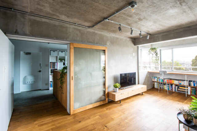 フローリングに用いたのは180mmの幅広のオーク材。玄関から奥に向かって貼るのが一般的だが、同物件ではあえて大きな窓とバルコニーがある東西に向けて貼り、視線の抜けと方向を揃えてさらなる広がりを演出した。引き戸のフレームも木製で統一感を出している