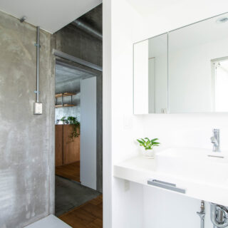 洗面室は白を基調にしてすっきりとシンプルにコーディネート。露出配管がコンクリートともマッチしている