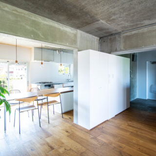 開口部をまたいで設置した収納は、玄関収納兼リビング収納として使える2wayスタイル。引き戸のウッドフレームが引き立つよう、この収納はラワン合板ではなく白い面材で造作した。空間全体を俯瞰し、素材や色のバランスを調整するのも設計者の大切な仕事