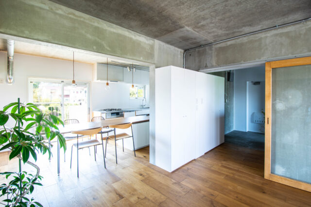 開口部をまたいで設置した収納は、玄関収納兼リビング収納として使える2wayスタイル。引き戸のウッドフレームが引き立つよう、この収納はラワン合板ではなく白い面材で造作した。空間全体を俯瞰し、素材や色のバランスを調整するのも設計者の大切な仕事