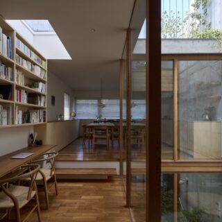 2階子世帯。中庭を介し、屋上庭園や青い空（写真右上）、階下の緑といった上下の広がりも感じられて抜群の開放感。中庭は敷地の北側に位置するが、南（写真左）から入る日差しが北側のコンクリート壁に当たり、その反射光が室内に入るので、上階から下階まで柔らかく光が届く