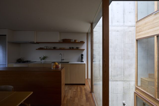 子世帯は2つのカウンターが並列するキッチンをオリジナルで造作し、写真手前のカウンターには高級感のあるチェリー材を使用。生活空間のインテリアになじむ家具のようなキッチンを目指し、引き出しや収納の取っ手をなくすなど細部にこだわってデザインした