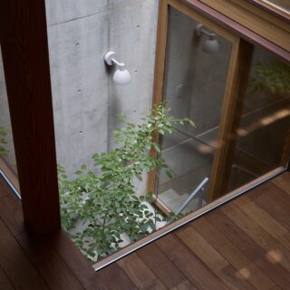 2階子世帯から中庭を見下ろす。「上への抜け感だけでなく、下にも抜け感があると開放感がいっそう増すと実感しました」と谷山さん夫妻。高級感漂うチークの床は庭の緑との相性もいい