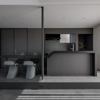 1階、3間×3間の正方形の中に配したLDK、リビングからキッチン、ダイニングを見る。アイランドキッチンは造作し、ダイニングテーブルと一体化させた。背面の棚には食器に加えて冷蔵庫を含む家電なども収納でき、生活感がない空間を実現。左壁面の仕切り戸は水回りに続く