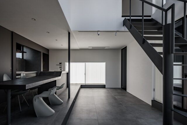 1階LDK。正方形のうち4分の1を吹き抜けとし、開放感をプラス。キッチン・ダイニングのエリアよりリビングのエリアの床レベルを下げ、段差を活用して居場所の多い空間をつくりあげた