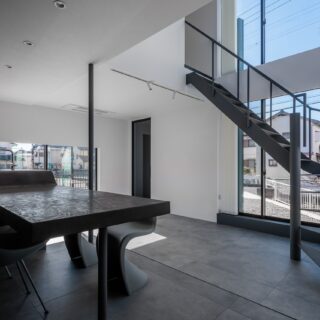 1階LDK。質感が感じられる素材をテーブルや床などに選び、かつ要望のモノトーン配色もグラデーションを取り入れて色味を決定した。おかげで室内に入る光から生まれる陰影が美しく、空間に奥行きが感じられるようになった