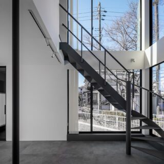 1階キッチン・ダイニングからリビング方向を見る。住宅街でこれだけの大開口ができるのは珍しい。外部へは窓からも直接行き来できるように計画しており、室内外を繋げてのバーベキューなども可能。2階の腰壁を高めに設定し、1階から個室へ伸びる視線を遮った