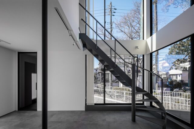 1階キッチン・ダイニングからリビング方向を見る。住宅街でこれだけの大開口ができるのは珍しい。外部へは窓からも直接行き来できるように計画しており、室内外を繋げてのバーベキューなども可能。2階の腰壁を高めに設定し、1階から個室へ伸びる視線を遮った