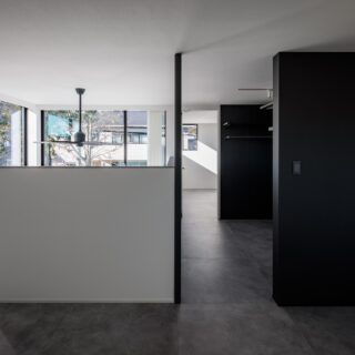 2階洋室（手前）、クローゼット（中央）、納戸（奥）。洋室は寝室として使用、クローゼットまで一続きとなっている。納戸はフレキシブルに使える空間。吹き抜けに接する腰壁は一般的な物より高めに設定。寝ている状態では窓が目に入らないようにし、寝室らしい落ち着きを与えた