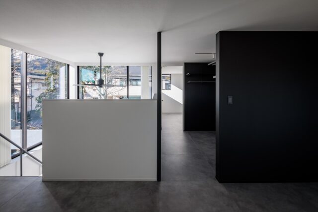 2階洋室（手前）、クローゼット（中央）、納戸（奥）。洋室は寝室として使用、クローゼットまで一続きとなっている。納戸はフレキシブルに使える空間。吹き抜けに接する腰壁は一般的な物より高めに設定。寝ている状態では窓が目に入らないようにし、寝室らしい落ち着きを与えた