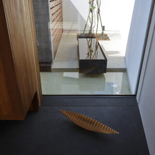 アプローチ奥にある坪庭には、水盆とコールテン鋼の水箱を。和室からもこの景色が見えるようにした。