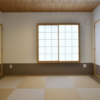 LDKの隣に、琉球畳に網代の天井をもつ和室。大きな仏壇は、来客時には目隠しできるよう扉もつけた。