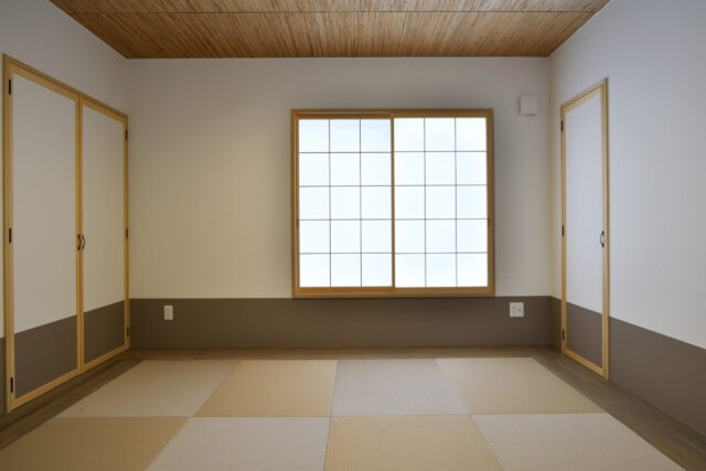 LDKの隣に、琉球畳に網代の天井をもつ和室。大きな仏壇は、来客時には目隠しできるよう扉もつけた。